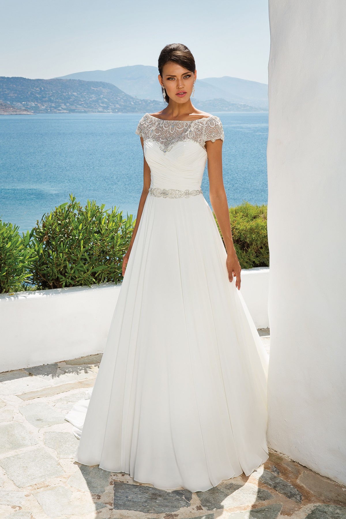 8799 - Aphrodite - Justin Alexander 8799, Chiffon Grecian Style A-line Wedding Dress with Beaded Off the Shoulder Neckline available at Blessings Bridal Boutique, Brighton, East Sussex, BN1 5GG. Telephone: 01273 505766