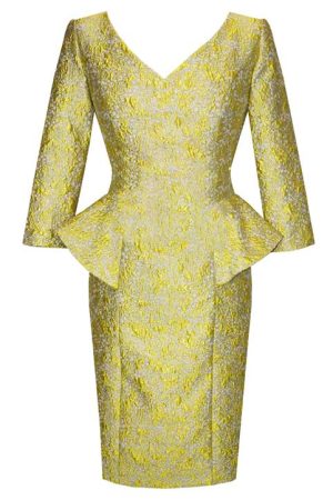 The Carla Ruiz - 94732 dress in yellow brocade features a fitted silhouette complemented by three-quarter length sleeves, a deep V-neckline, and a peplum detail at the waist. The textured floral pattern on the fabric adds a luxurious touch to this exquisite design.
