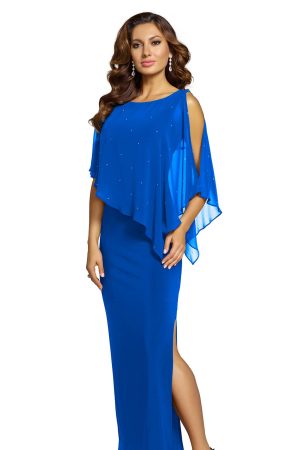 Dressed in a Frank Lyman 68004, a woman stands gracefully against a white background, her long blue dress with cape-like sleeves embodying an elegant style.