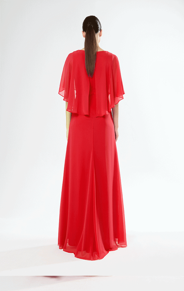 A vision in a flowing red gown with a cape-like top, reminiscent of Carla Ruiz's 51633 design, stands gracefully against a white background.