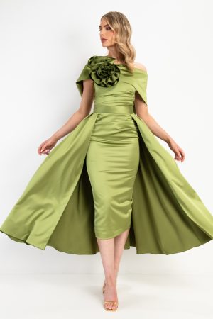 Woman in a light green, off-shoulder Kevan Jon - Kris dress featuring a large flower detail and a flared, cape-style skirt.