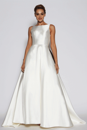 A woman models the Freda Bennet - Manhatten wedding gown in Size 12 (£849), a sleeveless, floor-length Ivory Mikado dress with a fitted boat neck bodice and Aline shape skirt.